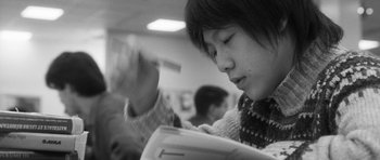 Movie still from “Polytechnique” (2009), directed by Denis Villeneuve – A person sitting in front of a window holding papers; Extreme Close Up shot, Low angle