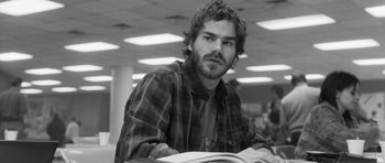 Movie still from “Polytechnique” (2009), directed by Denis Villeneuve – Black and white photograph of a man reading a book; Close Up shot, Low angle