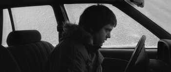 Movie still from “Polytechnique” (2009), directed by Denis Villeneuve – A man sitting in the passenger seat of a car; Close Up shot, Low angle
