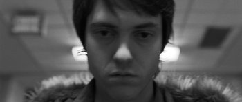Movie still from “Polytechnique” (2009), directed by Denis Villeneuve – A black - and - white photo of a man's face; Close Up shot, Low angle