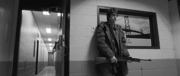 Movie still from “Polytechnique” (2009), directed by Denis Villeneuve – Black and white photograph of a man leaning against a wall; Medium shot, Low angle