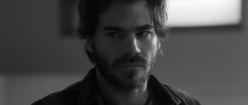 Movie still from “Polytechnique” (2009), directed by Denis Villeneuve – Black and white photograph of a man with a beard; Close Up shot, Over the shoulder angle