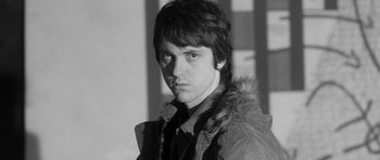 Movie still from “Polytechnique” (2009), directed by Denis Villeneuve – Black and white photograph of a young man in a fur trimmed jacket; Close Up shot, Low angle