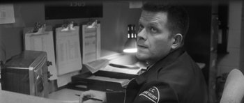 Movie still from “Polytechnique” (2009), directed by Denis Villeneuve – A man sitting in front of a computer desk; Close Up shot, High angle