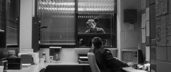 Movie still from “Polytechnique” (2009), directed by Denis Villeneuve – A man sitting in front of a computer screen; Wide shot, Over the shoulder angle