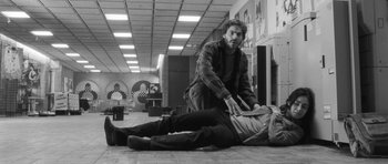 Movie still from “Polytechnique” (2009), directed by Denis Villeneuve – A man helping another man who is laying on the ground; Wide shot, Low angle