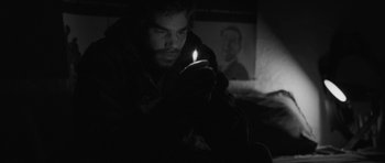 Movie still from “Polytechnique” (2009), directed by Denis Villeneuve – A man is holding a candle in a dark room; Close Up shot, Over the shoulder angle