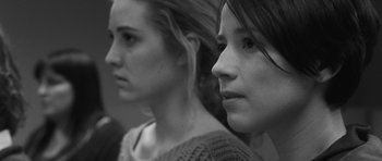 Movie still from “Polytechnique” (2009), directed by Denis Villeneuve – Two young women are standing next to each other; Close Up shot, Low angle