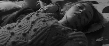 Movie still from “Polytechnique” (2009), directed by Denis Villeneuve – A woman laying on her stomach in a sweater; Extreme Close Up shot, High angle