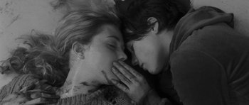 Movie still from “Polytechnique” (2009), directed by Denis Villeneuve – Two people laying on the ground with their hands over their mouths; Close Up shot, Overhead angle