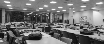 Movie still from “Polytechnique” (2009), directed by Denis Villeneuve – A room filled with lots of tables and chairs; Extreme Wide shot, High angle