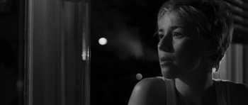Movie still from “Polytechnique” (2009), directed by Denis Villeneuve – A black - and - white photo of a woman looking out a window; Close Up shot, Low angle
