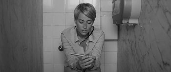 Movie still from “Polytechnique” (2009), directed by Denis Villeneuve – A woman sitting on a toilet looking at her cell phone; Close Up shot, Overhead angle
