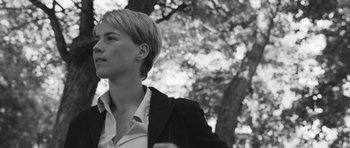 Movie still from “Polytechnique” (2009), directed by Denis Villeneuve – Black and white photograph of a woman in front of a tree; Medium shot, Low angle