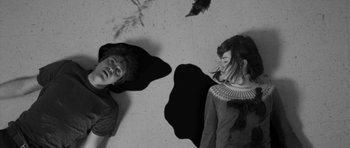 Movie still from “Polytechnique” (2009), directed by Denis Villeneuve – Two people laying on the ground in a room; Medium shot, Overhead angle