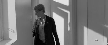 Movie still from “Polytechnique” (2009), directed by Denis Villeneuve – A black and white photo of a woman in a business suit; Medium shot, Low angle
