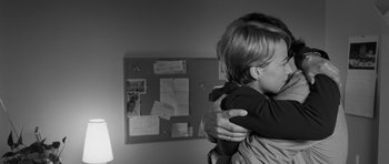 Movie still from “Polytechnique” (2009), directed by Denis Villeneuve – A young child is hugging a woman in a room; Close Up shot, Over the shoulder angle