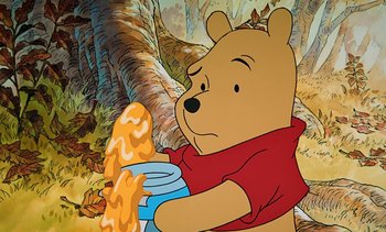 Movie still from “Pooh's Grand Adventure: The Search for Christopher Robin” (1997), directed by Karl Geurs – Winnie the pooh is holding a jar of honey; Medium shot, Low angle