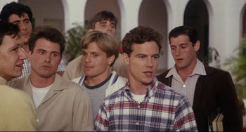 Movie still from “Porky's” (1981), directed by Bob Clark – A group of young men standing next to each other in front of an archway; Medium shot, Over the shoulder angle