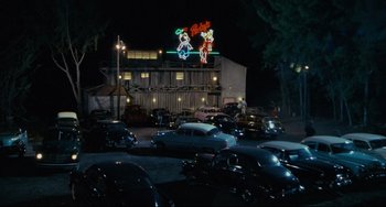 Movie still from “Porky's” (1981), directed by Bob Clark – Cars are parked in a parking lot at night; Extreme Wide shot, High angle