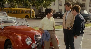 Movie still from “Porky's” (1981), directed by Bob Clark – Two young men standing next to a red car; Medium shot, Low angle