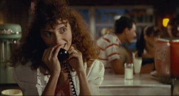 Movie still from “Porky's” (1981), directed by Bob Clark – A woman talking on a phone while sitting at a table; Close Up shot, Over the shoulder angle
