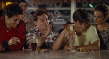 Movie still from “Porky's” (1981), directed by Bob Clark – Two young men sitting at a table eating food; Medium shot, Over the shoulder angle