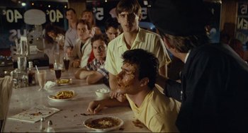 Movie still from “Porky's” (1981), directed by Bob Clark – A group of people sitting at a table with food on it; Medium shot, Over the shoulder angle