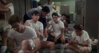 Movie still from “Porky's” (1981), directed by Bob Clark – A group of young men sitting on the ground; Medium shot, High angle