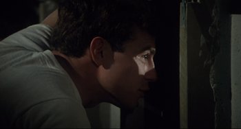 Movie still from “Porky's” (1981), directed by Bob Clark – A young man looking into the light from a window; Close Up shot, Low angle