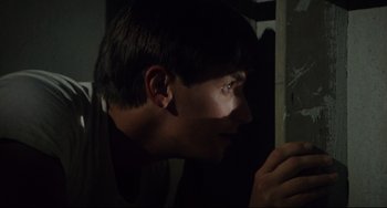 Movie still from “Porky's” (1981), directed by Bob Clark – A young man looking out a window at night; Close Up shot, Low angle