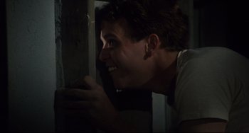 Movie still from “Porky's” (1981), directed by Bob Clark – A young man leaning up against a wooden wall; Close Up shot, Low angle