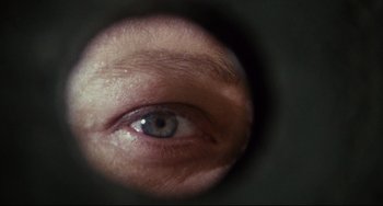 Movie still from “Porky's” (1981), directed by Bob Clark – A person's eye looking through a lens; Extreme Close Up shot, Overhead angle