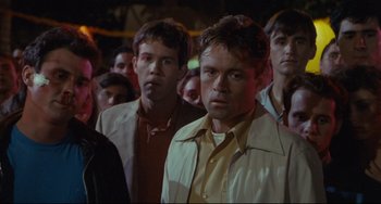 Movie still from “Porky's” (1981), directed by Bob Clark – A group of men standing next to each other in the dark; Medium shot, Over the shoulder angle