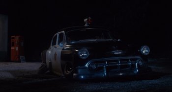Movie still from “Porky's” (1981), directed by Bob Clark – An old police car parked in the dark; Wide shot, Low angle