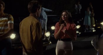 Movie still from “Porky's” (1981), directed by Bob Clark – A woman talking to a man on the side of the road; Medium shot, Over the shoulder angle