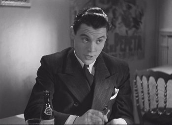 Movie still from “Port of Shadows” (1938), directed by Marcel Carné – A black and white photo of a man in a suit and tie; Close Up shot, High angle