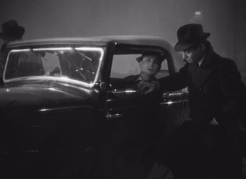 Movie still from “Port of Shadows” (1938), directed by Marcel Carné – Two men in a car looking out of the window; Medium shot, Low angle