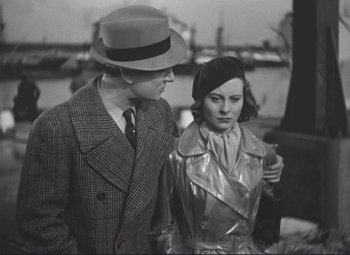 Movie still from “Port of Shadows” (1938), directed by Marcel Carné – A man and a woman standing next to each other; Medium shot, Over the shoulder angle