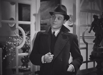 Movie still from “Port of Shadows” (1938), directed by Marcel Carné – A man wearing a hat and a coat; Medium shot, High angle