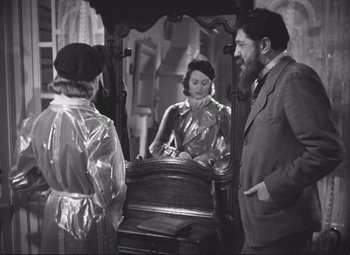 Movie still from “Port of Shadows” (1938), directed by Marcel Carné – A man and a woman standing in front of a mirror; Medium shot, Over the shoulder angle