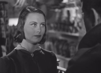 Movie still from “Port of Shadows” (1938), directed by Marcel Carné – A woman in a black dress is looking at a man in a black suit; Close Up shot, Over the shoulder angle