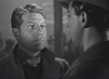 Movie still from “Port of Shadows” (1938), directed by Marcel Carné – A man looking at another man in the mirror; Close Up shot, Over the shoulder angle