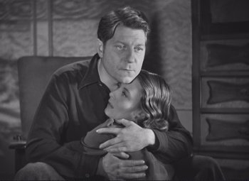 Movie still from “Port of Shadows” (1938), directed by Marcel Carné – A black and white photo of a man and a girl; Medium shot, Low angle