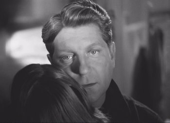 Movie still from “Port of Shadows” (1938), directed by Marcel Carné – A black - and - white photo of a man and a woman; Close Up shot, Over the shoulder angle