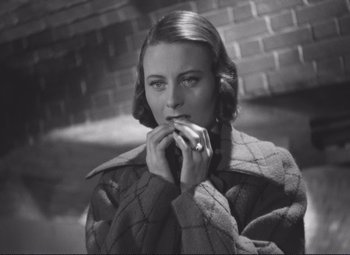 Movie still from “Port of Shadows” (1938), directed by Marcel Carné – A black - and - white photo of a woman in a blanket; Close Up shot, High angle