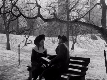 Movie still from “Portrait of Jennie” (1948), directed by William Dieterle – A man and a woman sitting on a park bench in the snow; Medium shot, High angle
