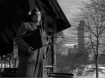 Movie still from “Portrait of Jennie” (1948), directed by William Dieterle – A man holding a briefcase standing in front of a building; Medium shot, Low angle