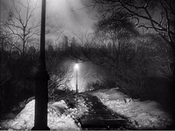 Movie still from “Portrait of Jennie” (1948), directed by William Dieterle – A street light on the side of the road in the snow; Extreme Wide shot, High angle