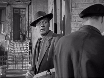 Movie still from “Portrait of Jennie” (1948), directed by William Dieterle – A man in a suit and hat talking to another man in a suit and hat; Medium shot, Over the shoulder angle